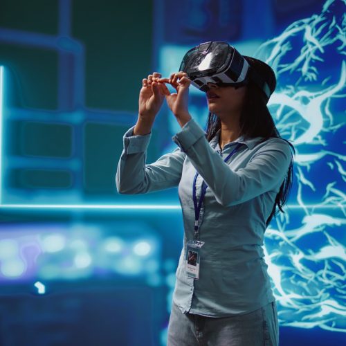 IT expert using VR headset, programming artificial intelligence computing simulating human brain. Technician uses virtual reality technology to build AI machine learning algorithms, camera B